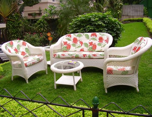 sofa e poltronas com mesa de centro em um jardim
